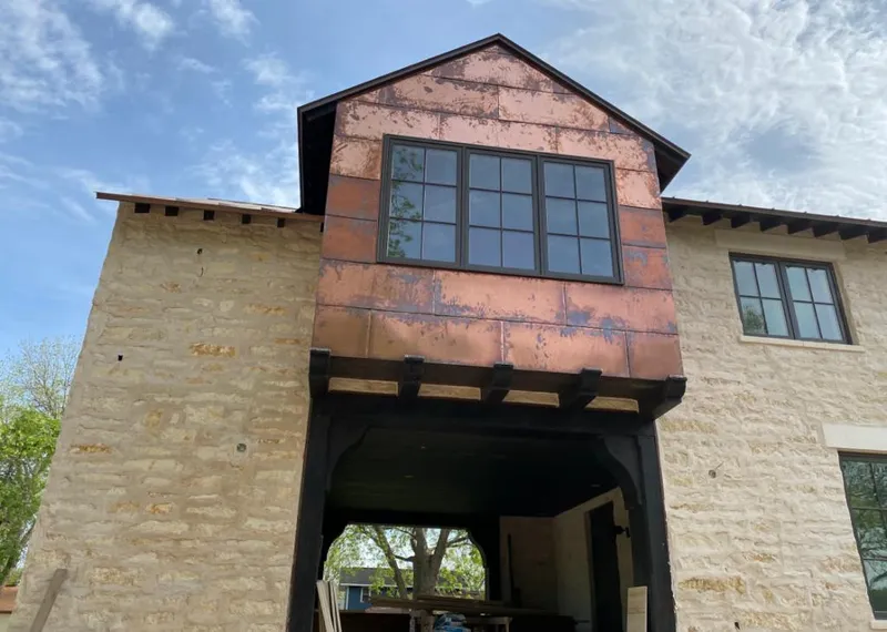 Copper metal panel facade on a stone building for Skylight Installation in Penn Forest